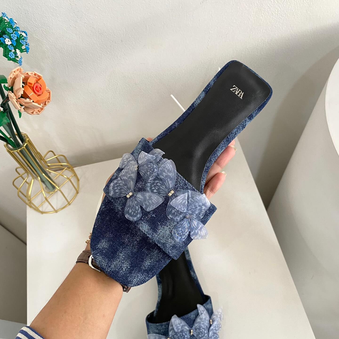 Flat denim sandals. Butterfly shaped embellishment at front